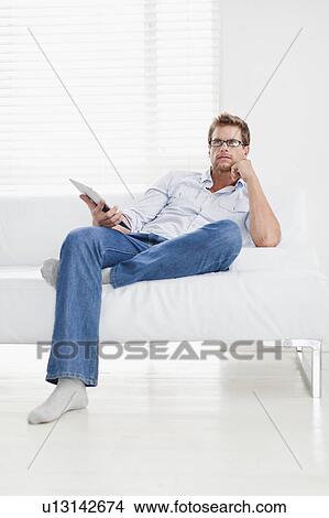 Man watching television on couch View Large Photo Image Picture - Man watching television on couch. Fotosearch