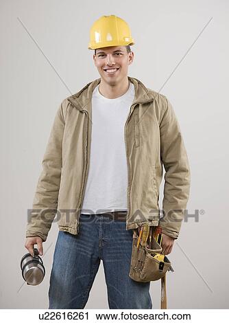 Stock Image - Man wearing hard hat and utility belt. Fotosearch