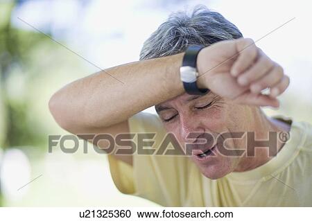 Man wiping sweat from his brow View Large Photo Image Stock Image - Man wiping sweat from his brow. Fotosearch