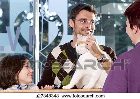 Stock Photo - Man with daughter and cat at vet. Fotosearch