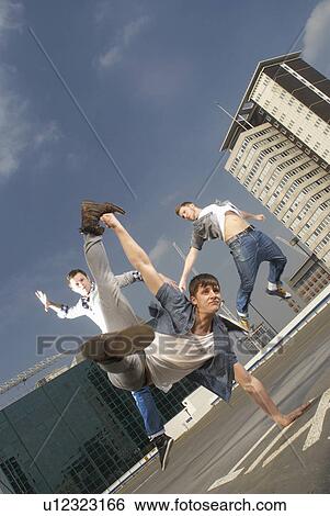 Stock Photograph - Men dancing on urban rooftop. Fotosearch