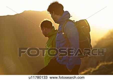 Stock Image - Men hiking on mountainside. Fotosearch
