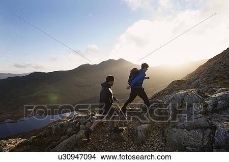 Picture - Men hiking on rocky mountainside. Fotosearch