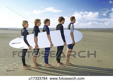 Men holding surfboard together View Large Photo Image Picture - Men holding surfboard together. Fotosearch