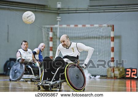 Stock Photo - Men in wheelchairs playing pararugby. Fotosearch