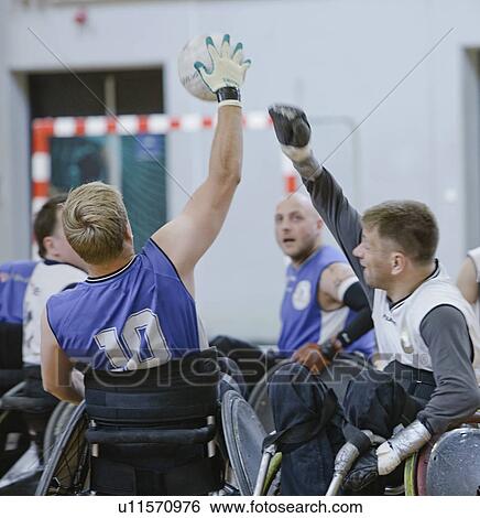 Stock Photograph - Men in wheelchairs playing pararugby. Fotosearch