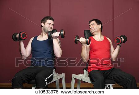 Men lifting weights together in gym View Large Photo Image Stock Photograph - Men lifting weights together in gym. Fotosearch