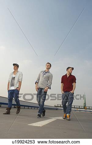 Men walking together on rooftop View Large Photo Image Stock Image - Men walking together on rooftop. Fotosearch