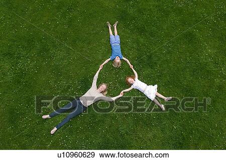 Stock Photo - Mother and children laying in grass. Fotosearch