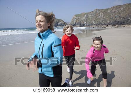 Stock Photo - Mother and children playing on beach. Fotosearch
