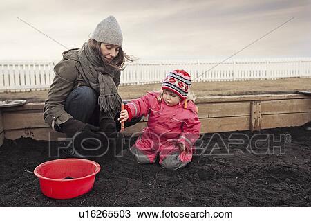 Mother and daughter digging outdoors View Large Photo Image Stock Image - Mother and daughter digging outdoors. Fotosearch