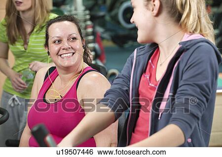 Stock Photograph - Mother and daughter exercising in gym. Fotosearch