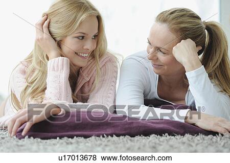 Stock Photo - Mother and daughter laying together. Fotosearch