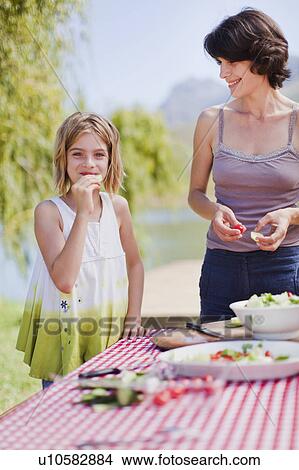 Picture - Mother and daughter making picnic lunch. Fotosearch