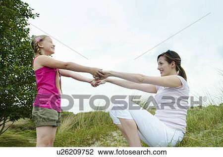 Mother and daughter playing on beach View Large Photo Image Stock Image - Mother and daughter playing on beach. Fotosearch