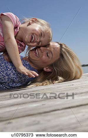Mother and daughter playing on dock View Large Photo Image Stock Image - Mother and daughter playing on dock. Fotosearch