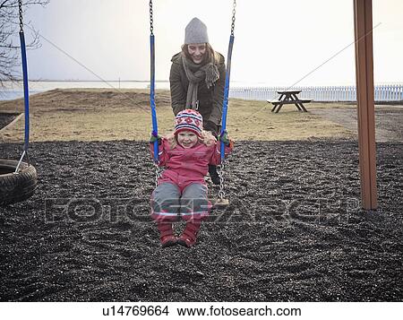 Picture - Mother and daughter playing on swings. Fotosearch