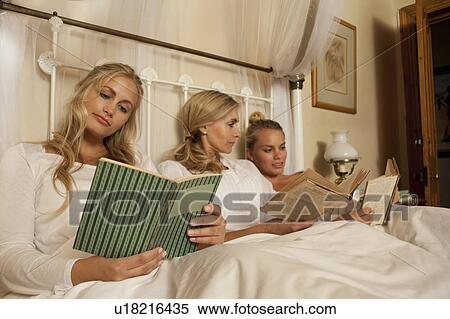 Mother and daughters reading in bed View Large Photo Image Stock Photography - Mother and daughters reading in bed. Fotosearch