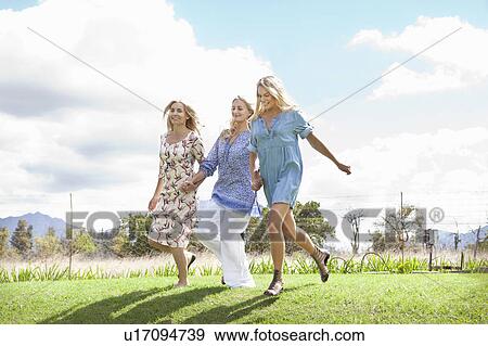 Mother and daughters running in garden View Large Photo Image Stock Photo - Mother and daughters running in garden. Fotosearch
