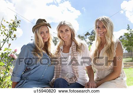 Stock Image - Mother and daughters sitting together. Fotosearch
