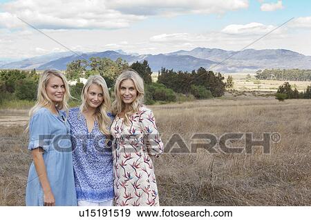 Stock Photo - Mother and daughters standing in field. Fotosearch