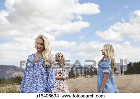 Stock Image - Mother and daughters walking in field. Fotosearch