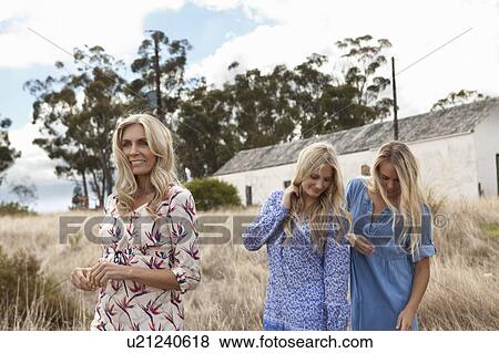 Mother and daughters walking in field View Large Photo Image Stock Photo - Mother and daughters walking in field. Fotosearch