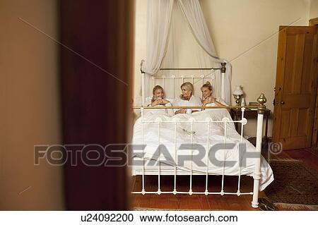 Mother and daughters with coffee in bed View Large Photo Image Stock Image - Mother and daughters with coffee in bed. Fotosearch