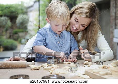 Stock Image - Mother and son baking in kitchen. Fotosearch
