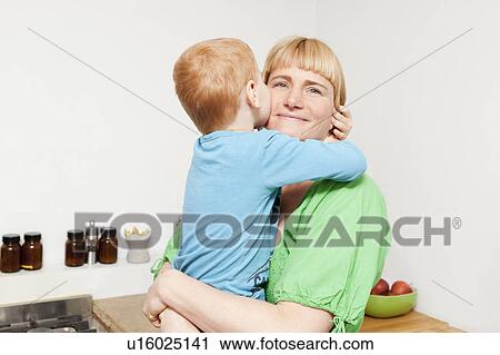 Mother and son hugging in kitchen View Large Photo Image Stock Image - Mother and son hugging in kitchen. Fotosearch