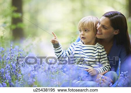 Stock Photography - Mother and son in field of flowers. Fotosearch