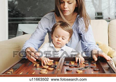Stock Image - Mother and son playing backgammon. Fotosearch