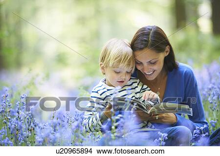 Picture - Mother and son reading in forest. Fotosearch