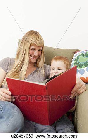 Mother and son reading together on sofa View Large Photo Image Stock Photo - Mother and son reading together on sofa. Fotosearch