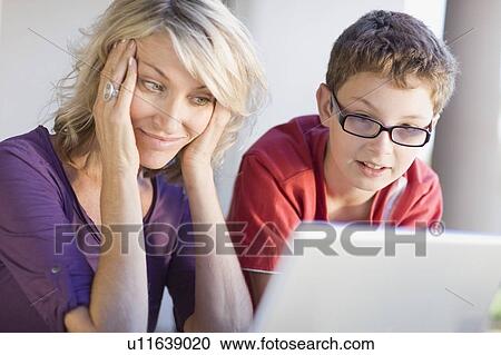 Mother and son using laptop together View Large Photo Image Stock Image - Mother and son using laptop together. Fotosearch