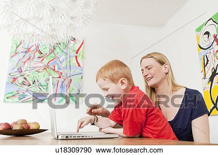 Stock Image - Mother and son using laptop together. Fotosearch
