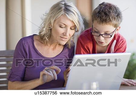 Mother and son using laptop together View Large Photo Image Stock Photograph - Mother and son using laptop together. Fotosearch