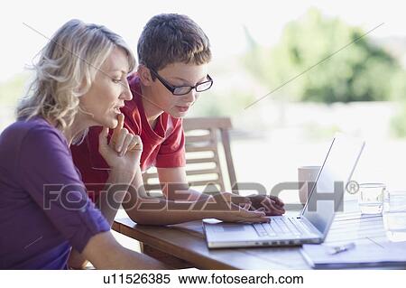 Mother and son using laptop together View Large Photo Image Stock Photography - Mother and son using laptop together. Fotosearch