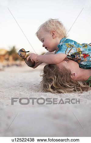 Mother and toddler son playing on beach View Large Photo Image Stock Photo - Mother and toddler son playing on beach. Fotosearch