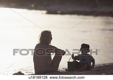 Stock Photo - Mother and toddler son playing on beach. Fotosearch
