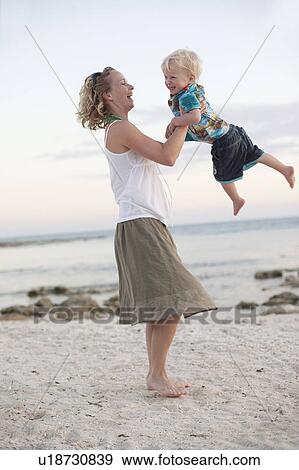 Mother and toddler son playing on beach View Large Photo Image Stock Photo - Mother and toddler son playing on beach. Fotosearch