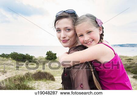 Mother carrying daughter piggy back View Large Photo Image Stock Photo - Mother carrying daughter piggy back. Fotosearch