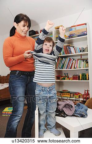 Mother helping son get dressed View Large Photo Image Stock Photography - Mother helping son get dressed. Fotosearch