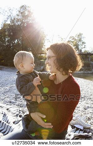 Mother holding baby by creek View Large Photo Image Picture - Mother holding baby by creek. Fotosearch
