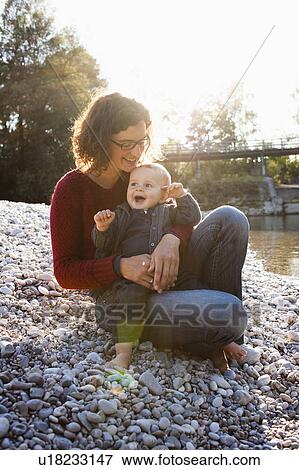 Stock Photo - Mother holding baby by creek. Fotosearch