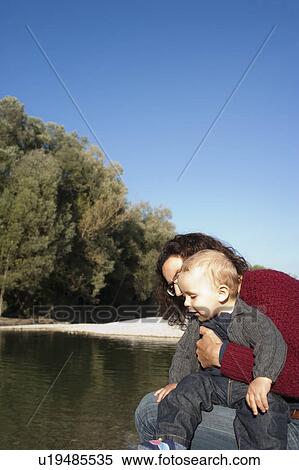 Mother holding baby by creek View Large Photo Image Stock Photography - Mother holding baby by creek. Fotosearch