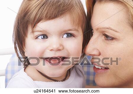 Stock Image - Mother holding baby daughter. Fotosearch