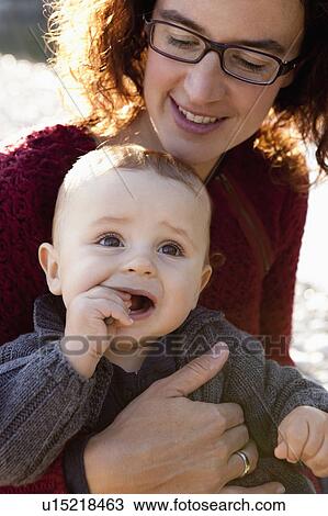 Mother holding baby outdoors View Large Photo Image Stock Image - Mother holding baby outdoors. Fotosearch