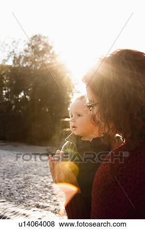 Stock Photo - Mother holding baby outdoors. Fotosearch