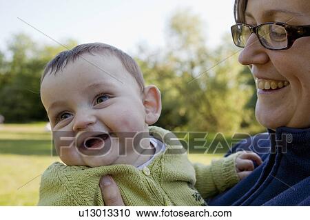 Mother holding laughing baby boy View Large Photo Image Stock Image - Mother holding laughing baby boy. Fotosearch